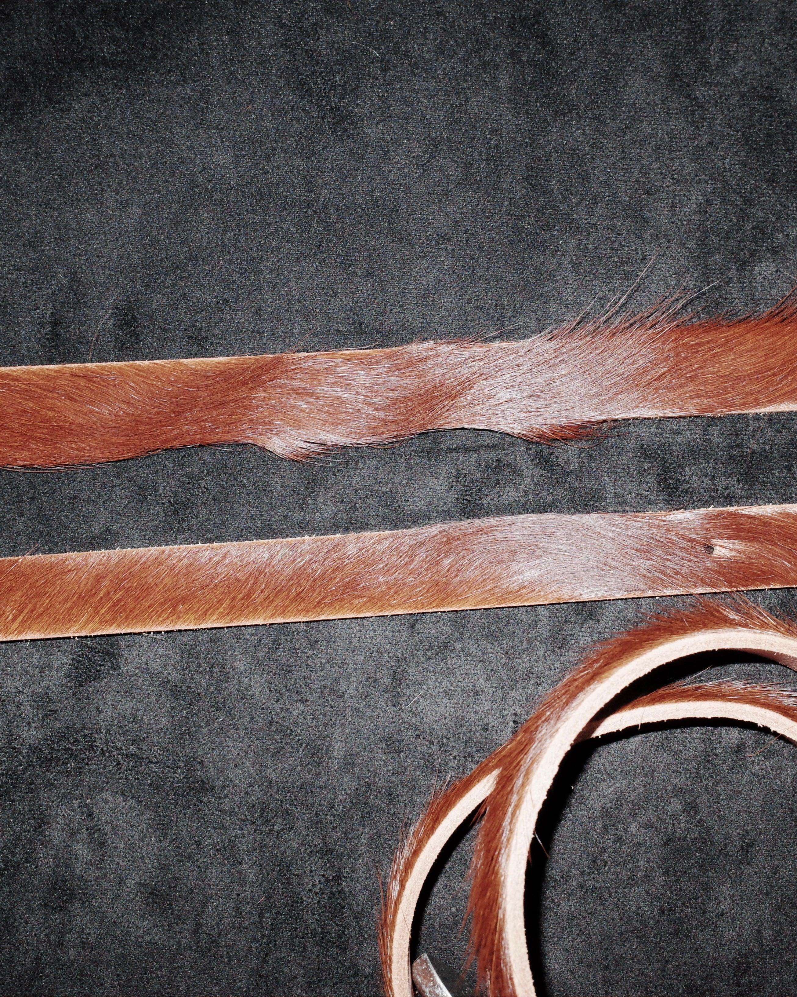 Close-up of cowhide hair on a textured black background