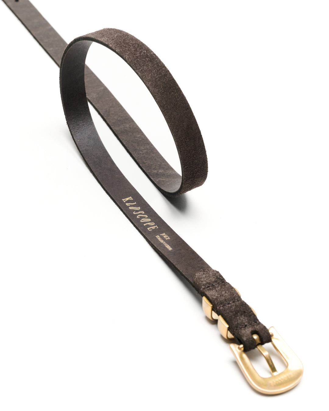 A Charcoal brown suede leather Western belt with a textured finish and a polished gold-tone buckle, shown on a clean white background. The brand name 'KLDSCOPE' is printed in gold on the strap.