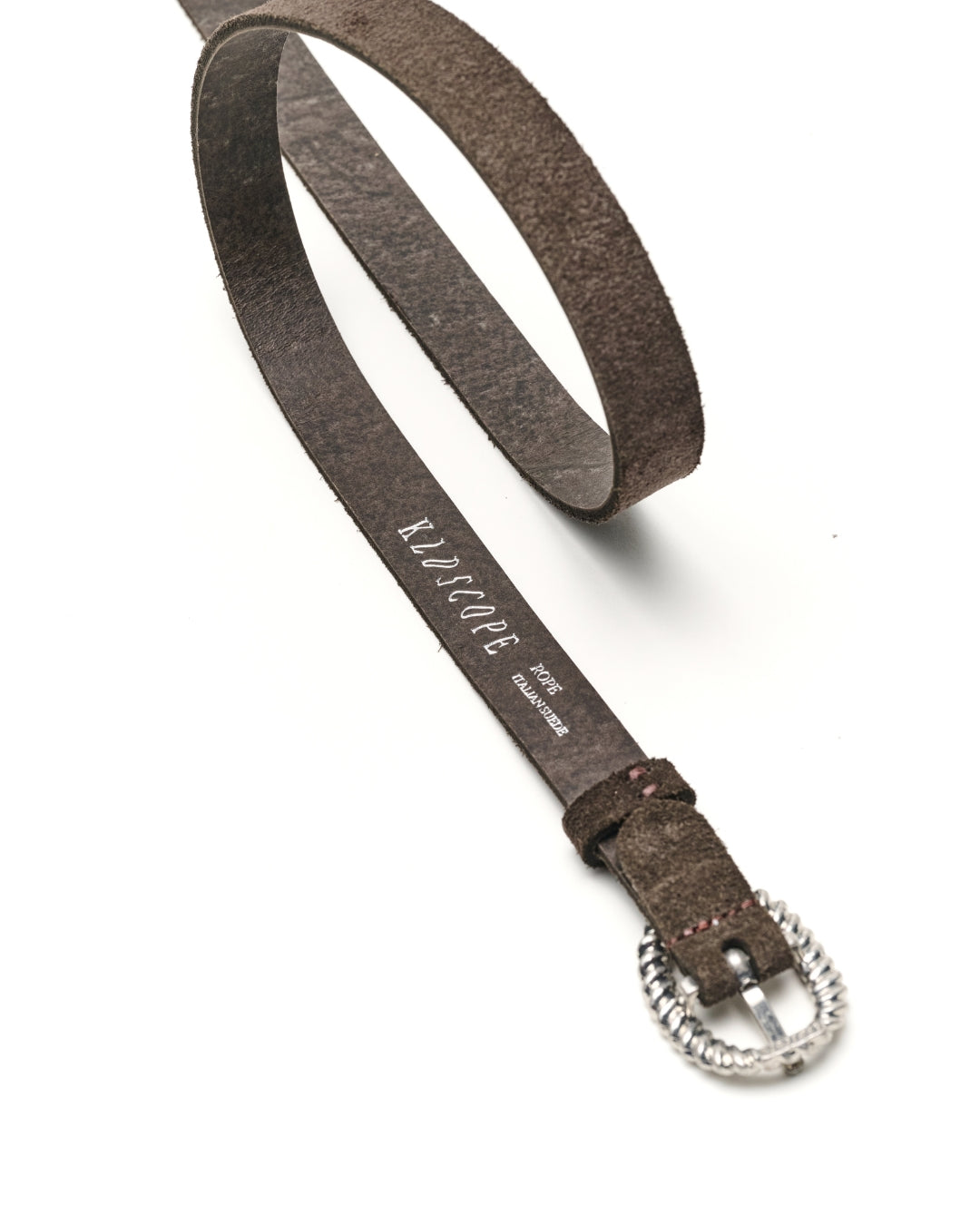 A charcoal brown leather belt with a textured silver-tone twisted buckle, shown on a clean white background. The brand name 'KLDSCOPE' is printed in white on the strap.