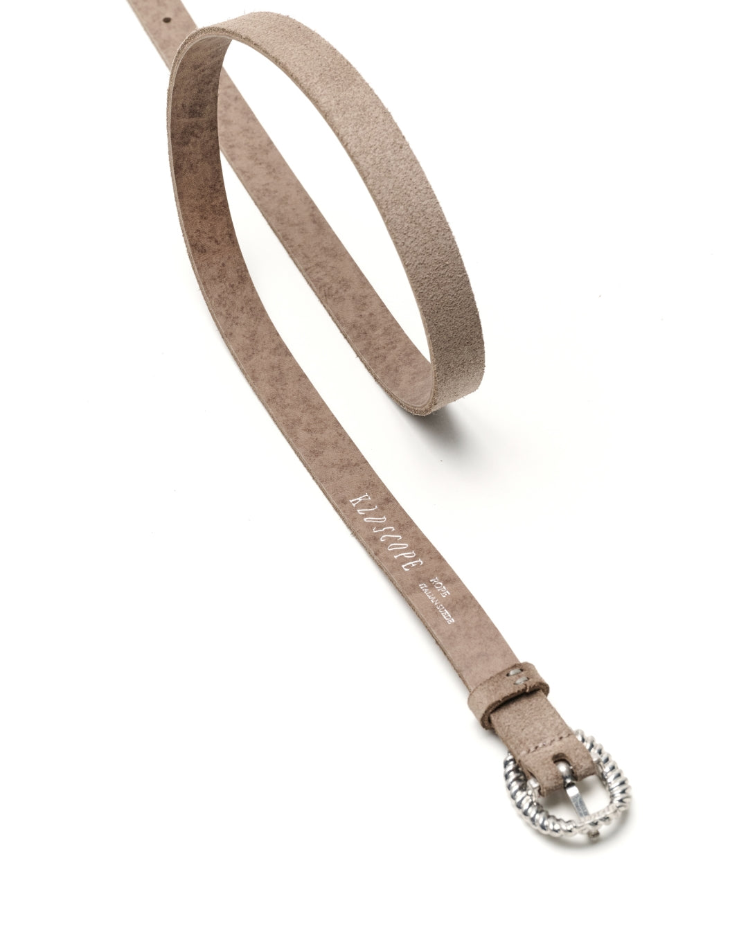 A sand-grey suede belt with a silver-tone twisted ring buckle, shown on a clean white background. The brand name 'KLDSCOPE' is printed in white script on the strap.