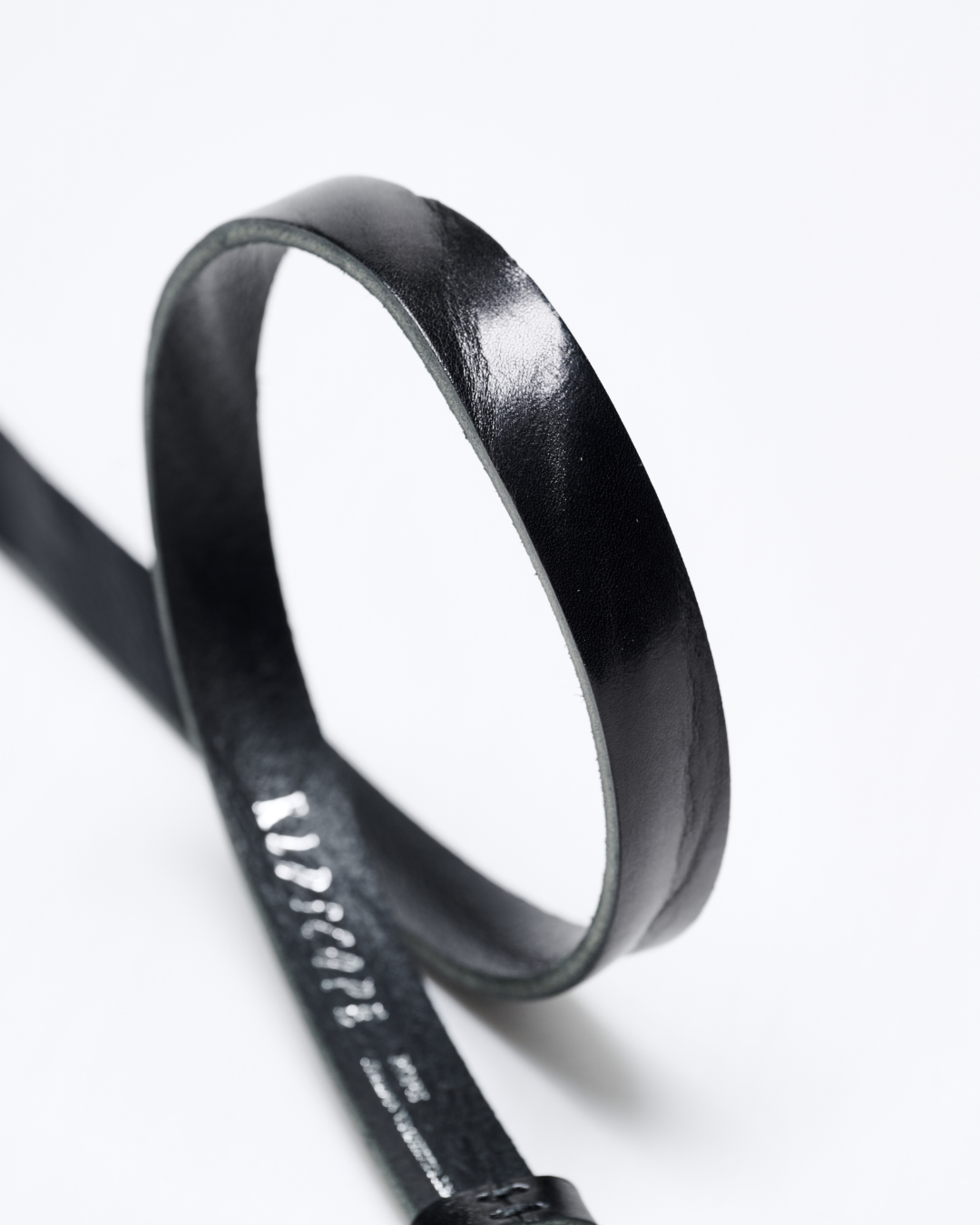 Black leather belt with a visible brand name on a white background