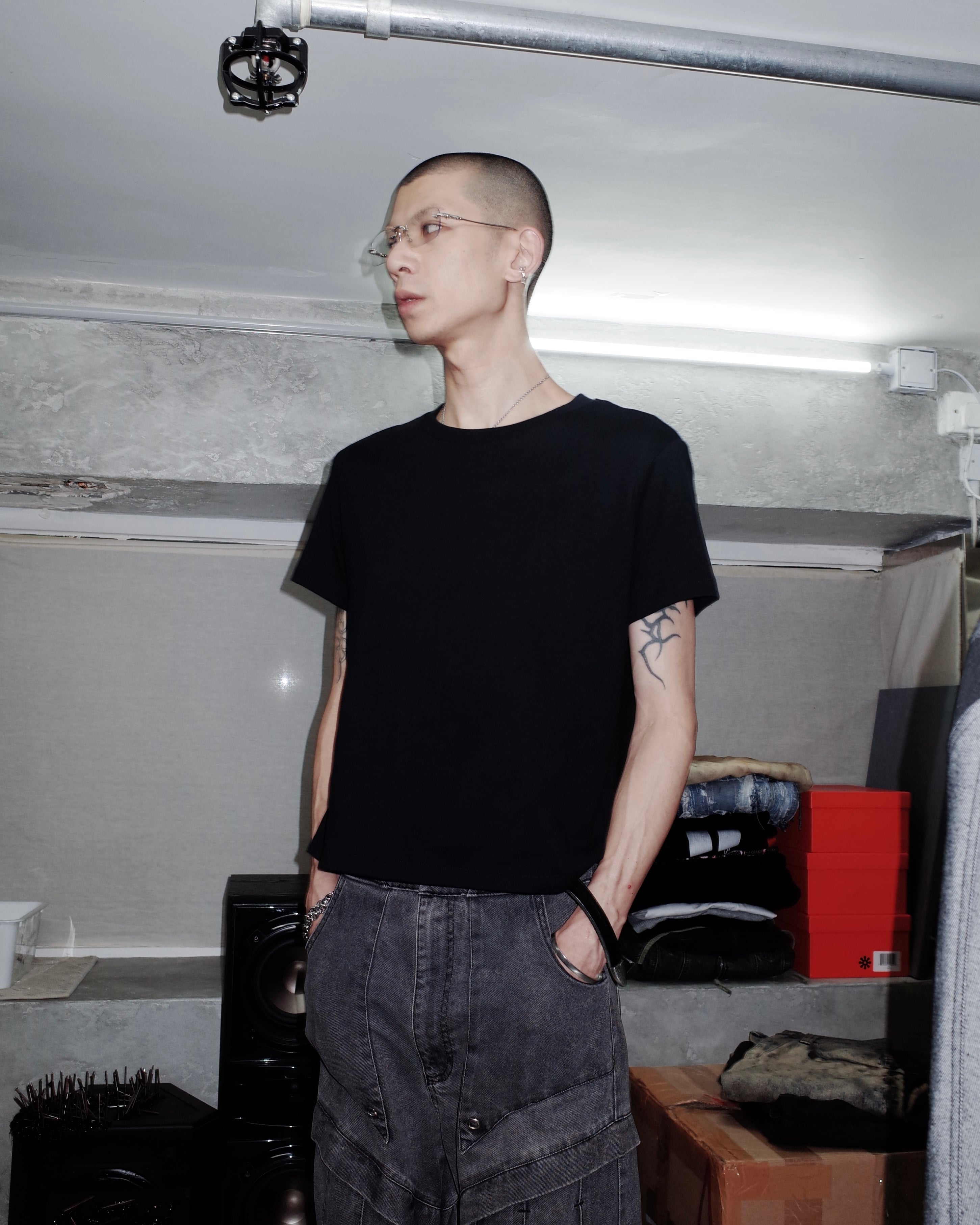 Person wearing a black t-shirt and dark pants in an indoor setting