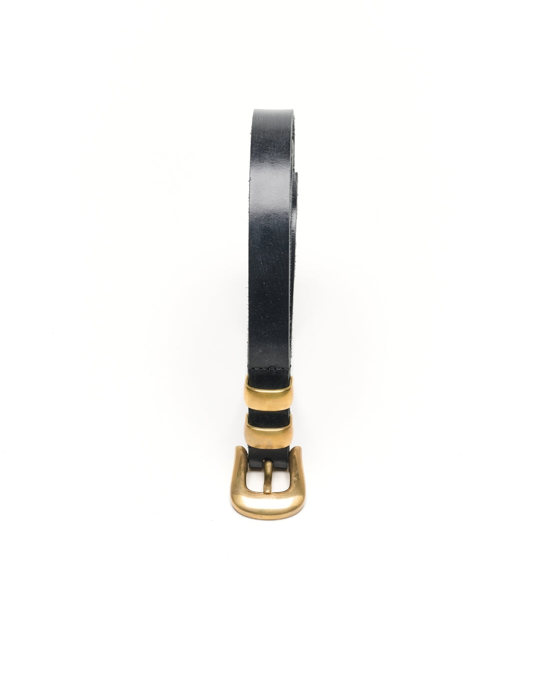 Close-up of the KLDSCOPE JOEY buckle and two keepers in unlacquered solid brass on black Sedgwick bridle leather.