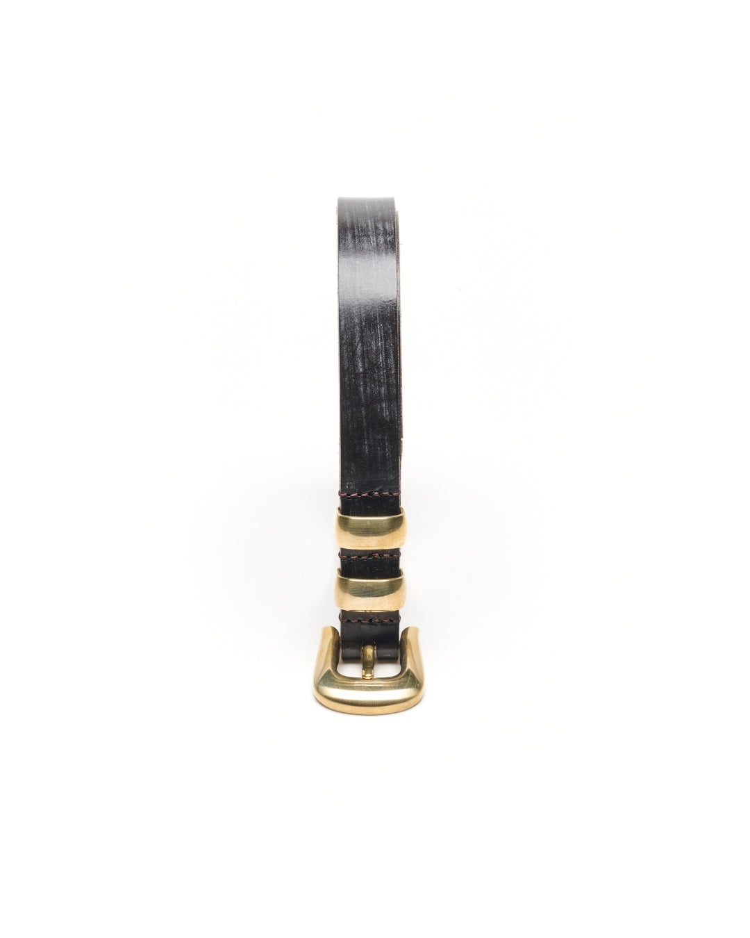 Close-up of the KLDSCOPE JOEY buckle and two keepers in unlacquered solid brass on Choco Sedgwick bridle leather.