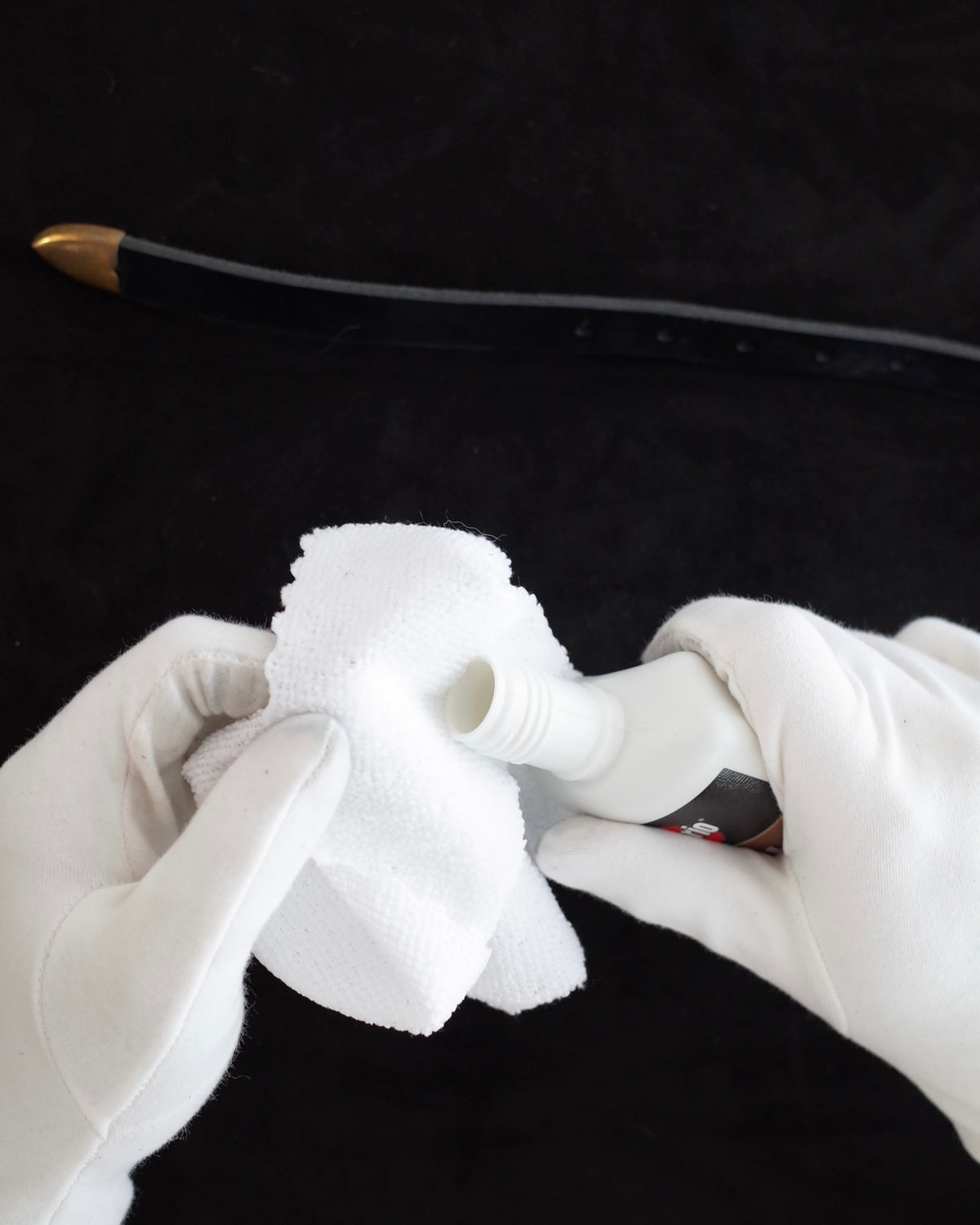 Applying a small amount of brass polish to a separate soft cotton cloth.